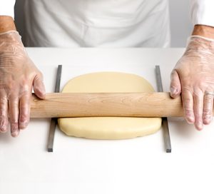 Using guides to roll dough.